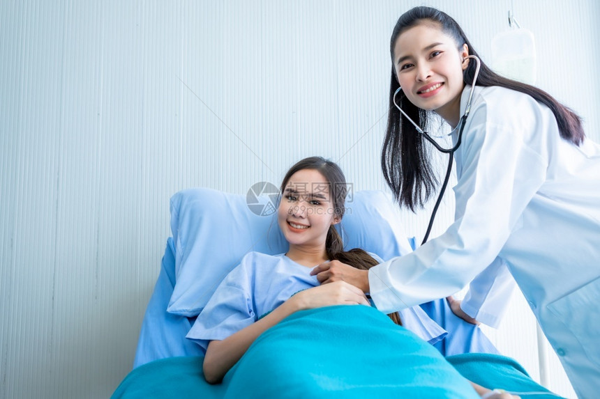 医生给病床上的年轻女病人看诊图片