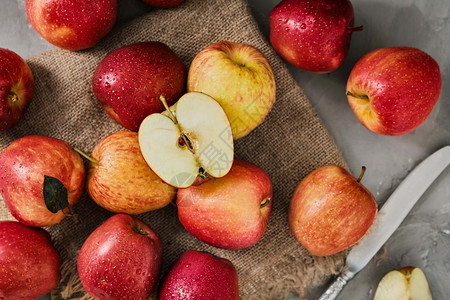 黑暗的充满活力来自当地农场的苹果水滴收成季节在灰色桌上布局有选择地关注半个苹果红汁做派的原料多汁背景