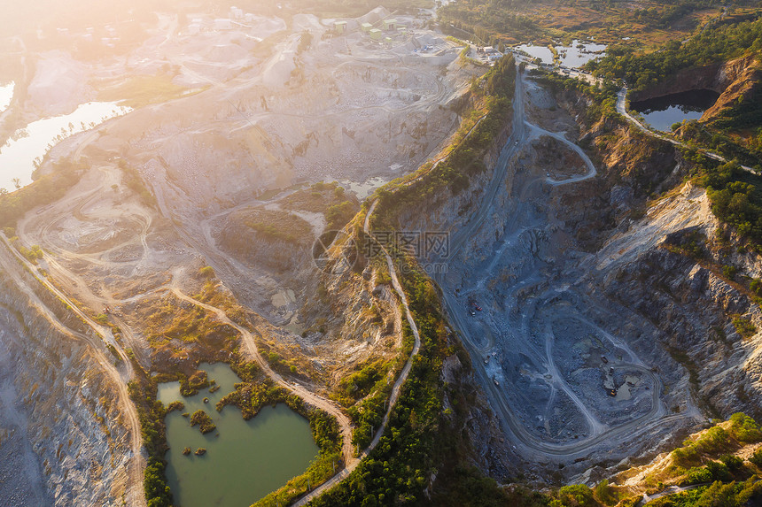 在森林起重机和生产花岗岩大理石矿场建筑设备之间的花岗岩采石场上空飞行造成气污染巨石采矿业Granite采矿业无人机材料建造图片