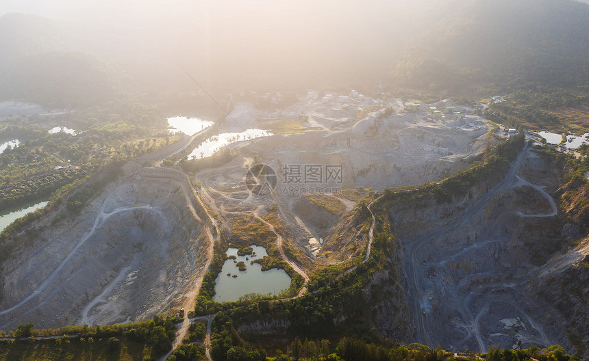 制造业环境在森林起重机和生产花岗岩大理石矿场建筑设备之间的花岗岩采石场上空飞行造成气污染巨石采矿业Granite采矿业地质学图片