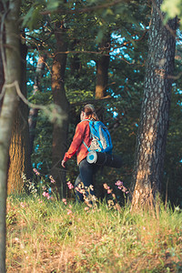 国民背包旅行泡沫在暑假期间带着背包走在穿过森林的道路上走过森林的青年妇女徒步旅行者女性高清图片素材