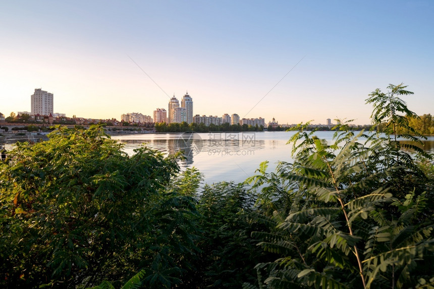 乌克兰基辅Dnieper河附近的高奥波隆建筑乌克兰基辅Dniper河蓝亮的天空和在水中反射各种植物和地表被城市的波浪景观图片