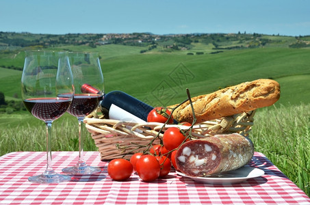 小吃红酒面包和番茄在彩布上与意大利的托斯卡纳风景对抗农村柏图片