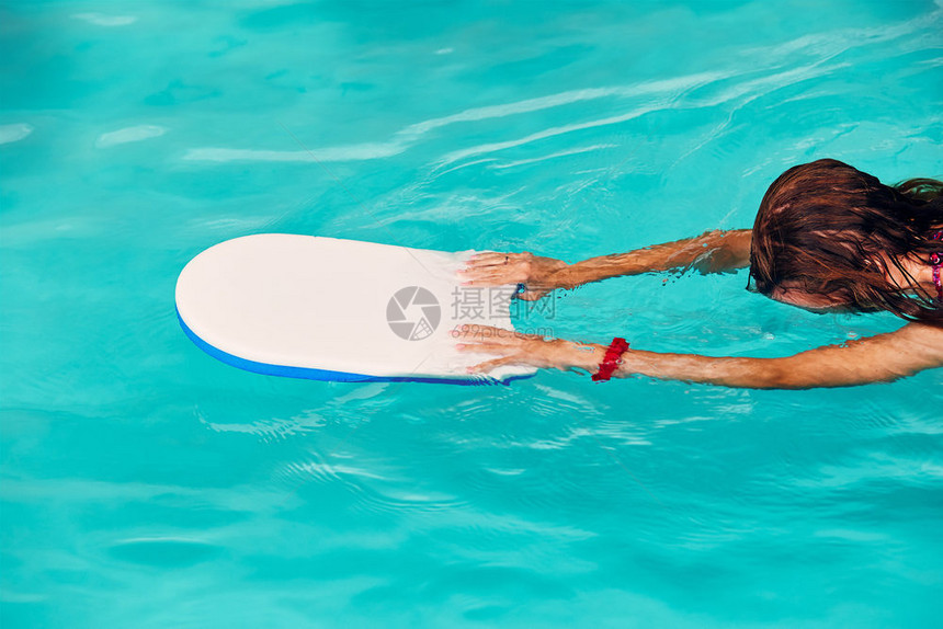 爱好女人学习游泳在池里练习使用董事会的Candid人真正的瞬间实情况人们夏天图片