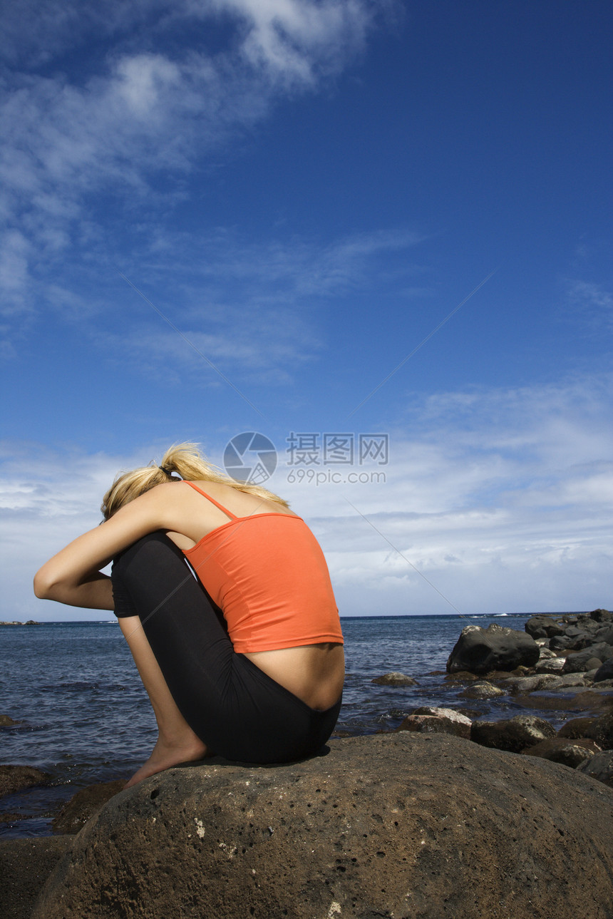 坐在岩石岸上的女人支撑海滩女士热带海岸女性孤独金发胎位照片图片