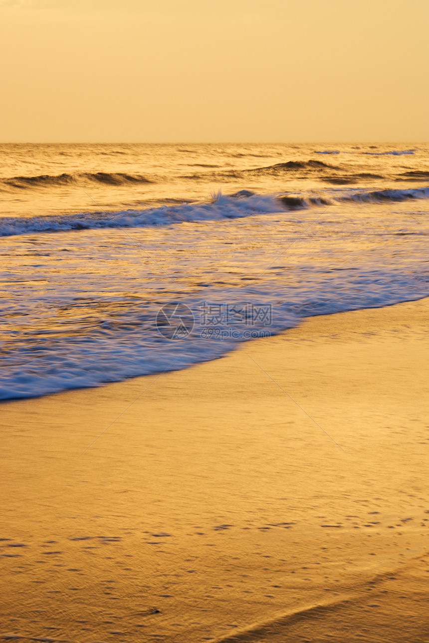 日落时波浪在海滩摇晃海岸风景海浪旅行黄色支撑照片海洋旅游假期图片