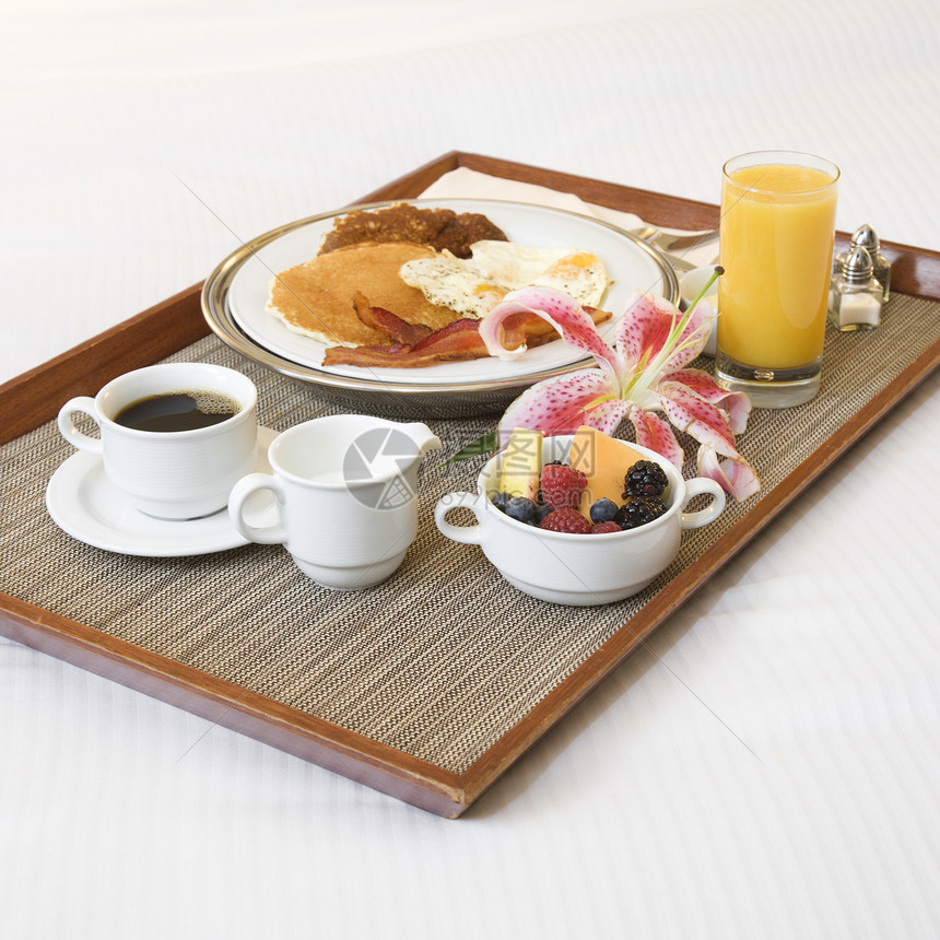 白床上的早餐盘水果酒店橙汁熏肉客房奢华饮料咖啡托盘服务图片
