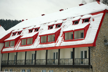 屋顶的雪被雪覆盖的屋顶窗户阳台酒店高山背景