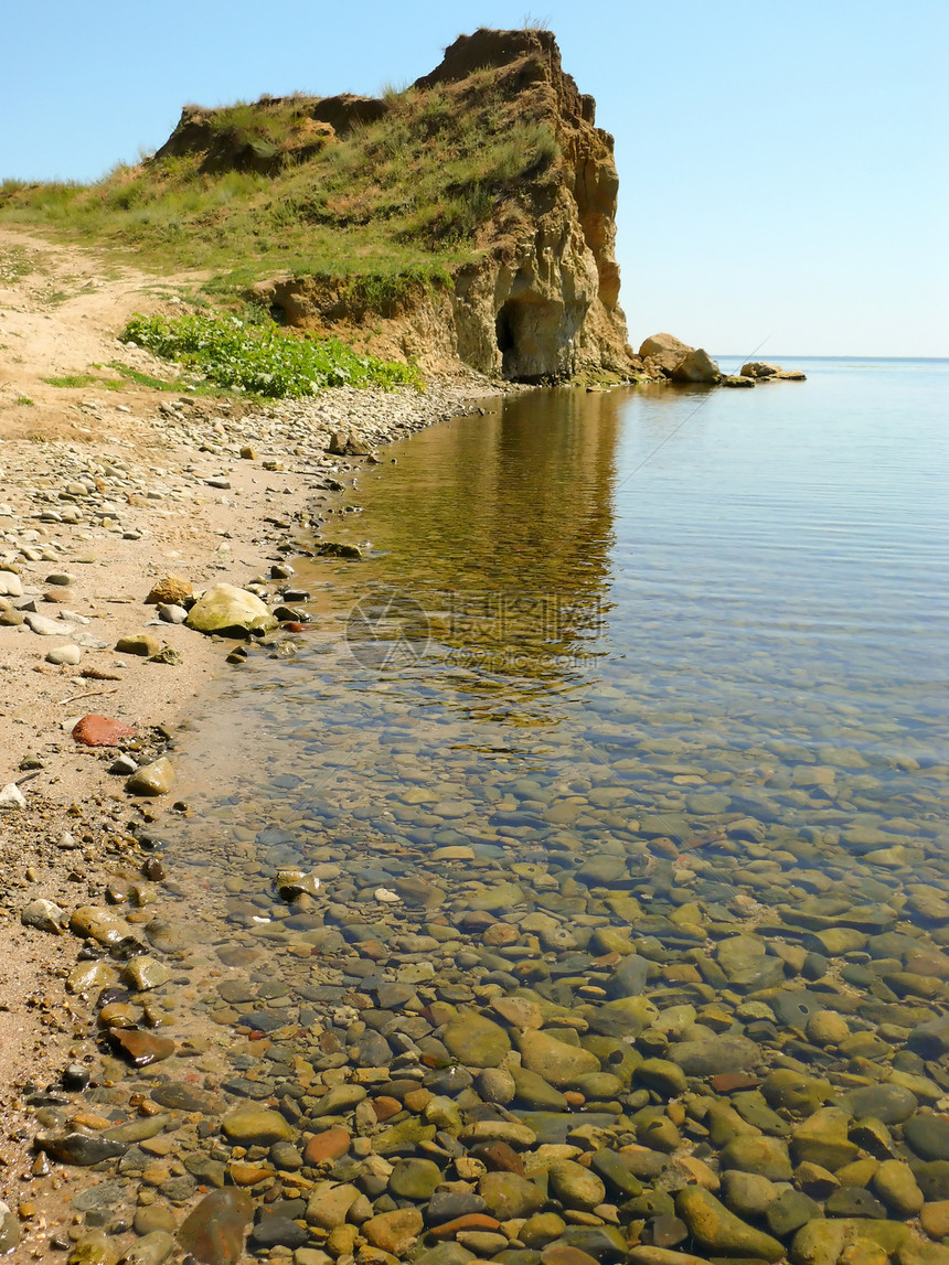 海滩岩石海洋卵石悬崖蓝色太阳池塘海岸线阳光草丛图片