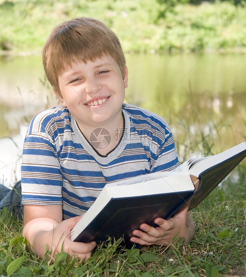 男孩读一本书阅读男性学习闲暇文学场地教育孩子们男生说谎图片