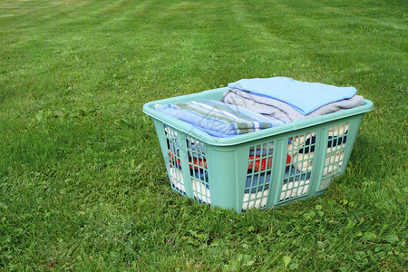 绿色衣服素材洗衣房中的衣物塑料院子绿色阻碍草地琐事衣服篮子折叠毛巾背景