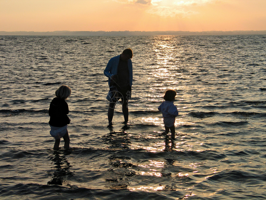 日落时的家庭阳光乐趣孩子女儿闲暇天空父亲太阳幸福海岸线图片