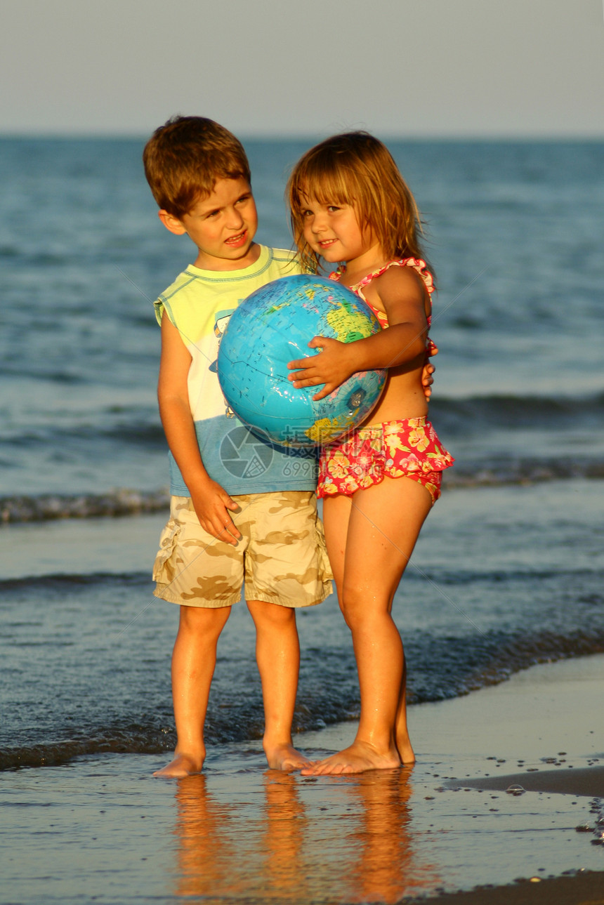 在海滩上玩球的男女小男孩图片