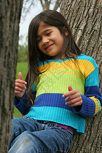 可爱的小女孩坐在树上坐着背景图片