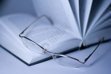 打开的书和眼镜智力文化大学文学蓝色学习教育故事调子智慧字典高清图片素材