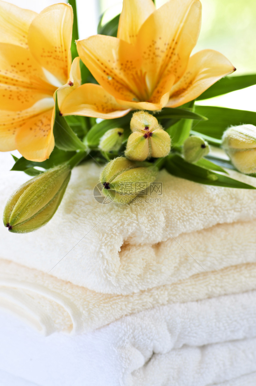 堆叠着鲜花的毛巾投标橙子花朵温泉奢华身体桑拿奶油折叠浴室图片