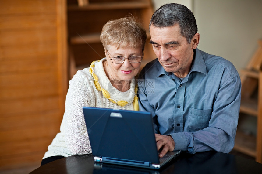 膝上笔记本电脑上的老年夫妇图片