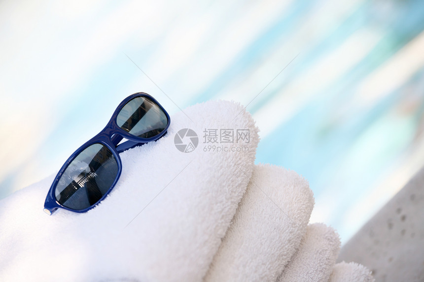 泳池间毛巾和太阳镜图片