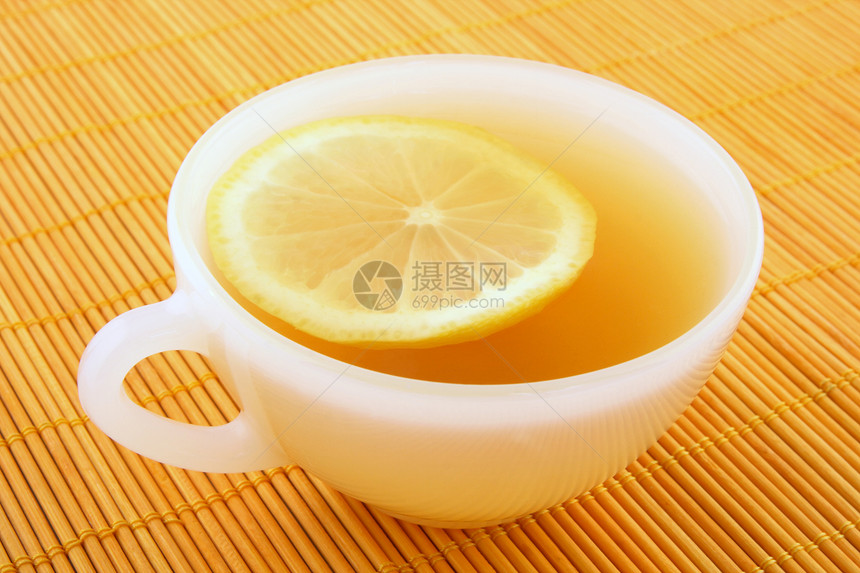 一杯加柠檬的茶 在温暖的金色阳光下图片