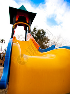 滑动孩子黄色孩子们天空娱乐橙子乐趣公园绿色游戏背景图片