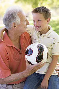 外祖父和孙孙子户外 带着球的微笑背景图片