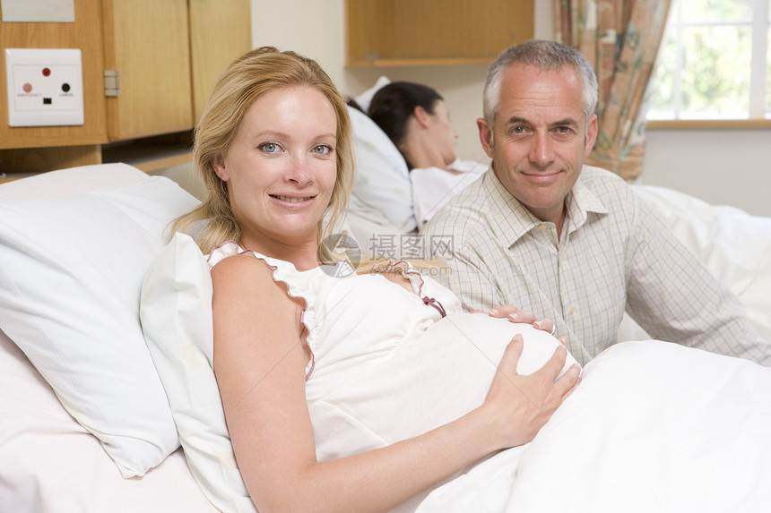 带着丈夫在医院中微笑的孕妇医疗家庭怀孕准妈妈男性待产三个人女士中年相机图片