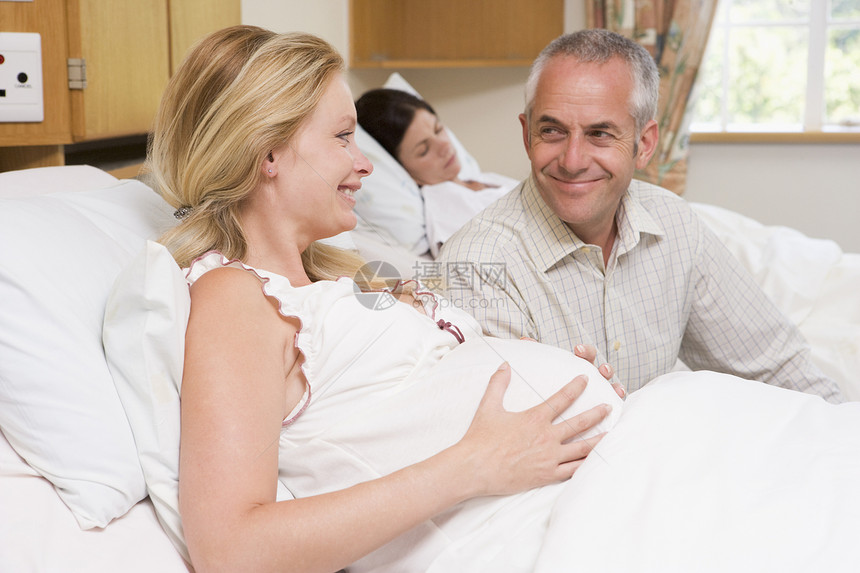 带着丈夫在医院中微笑的孕妇怀孕准妈妈保健医疗待产病房中年产房家庭女士图片