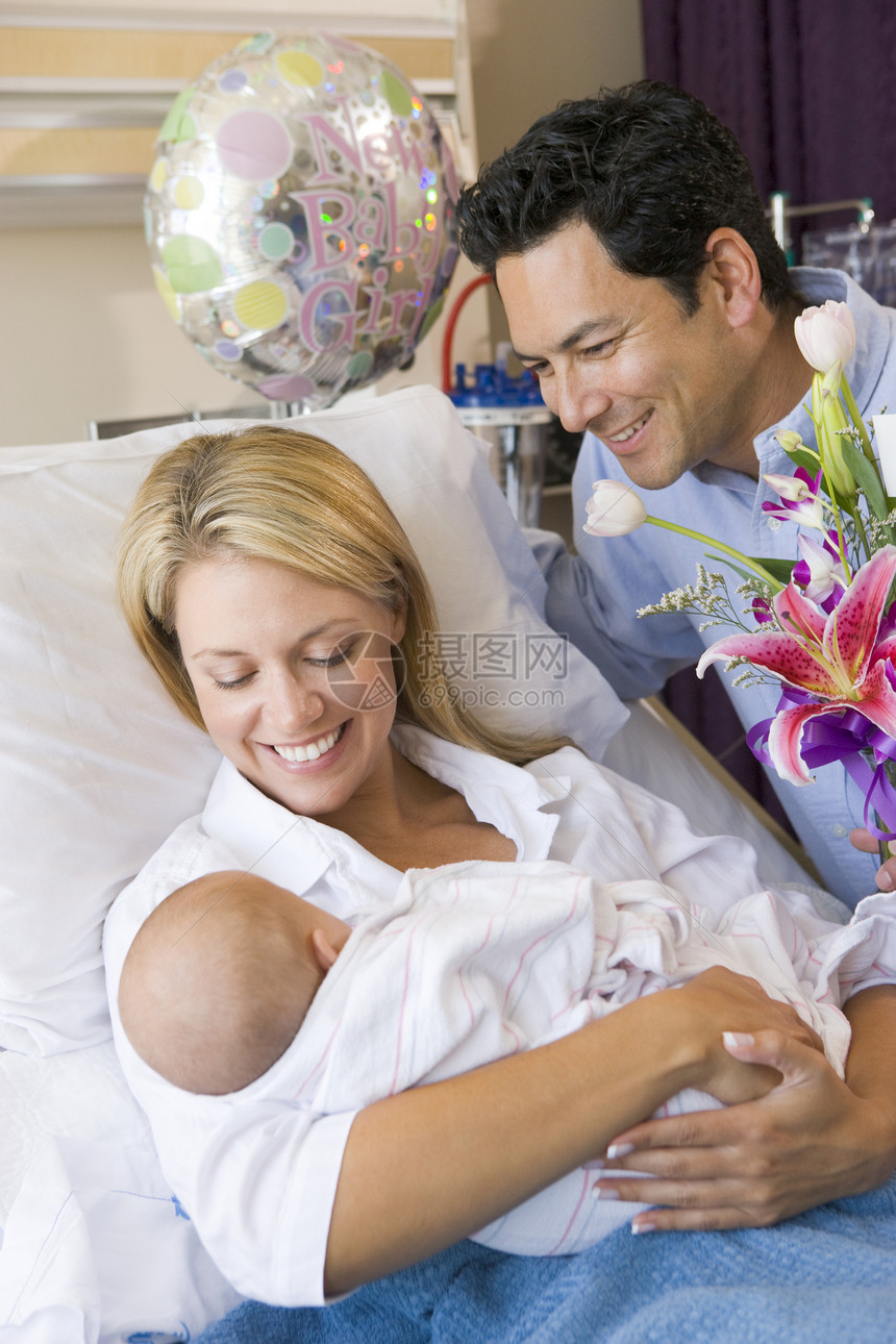 新母亲带着婴儿和丈夫在医院中微笑的笑容女孩新妈妈三个人女儿拥抱孕妇装女士访问妈妈新生儿图片