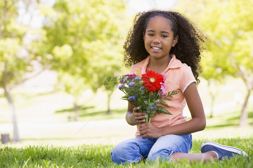 年轻女孩拿着鲜花微笑公园孩子们水平花朵相机情感农村长度孩子女性图片