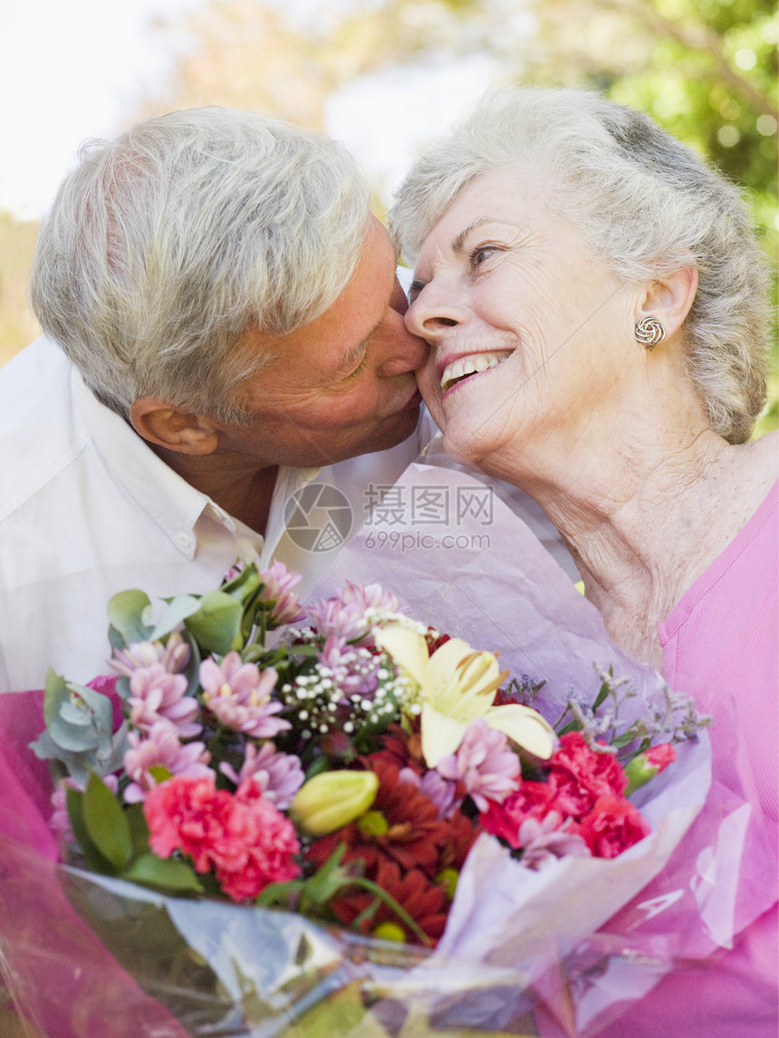 丈夫给妻子送花 在户外亲吻和微笑图片