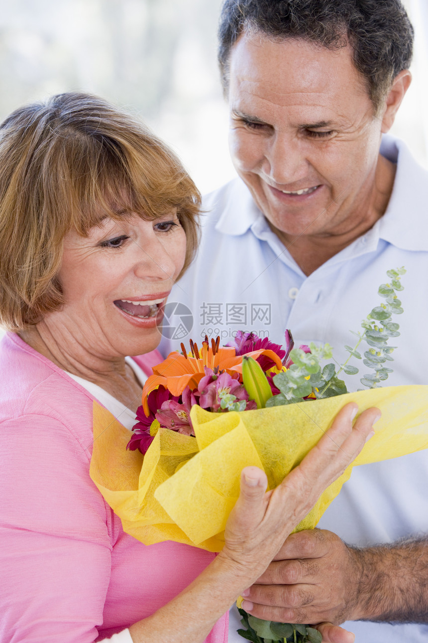 丈夫和妻子拿着鲜花 微笑着笑容纪念日男性退休礼物男人女士展示浪漫花朵感情图片