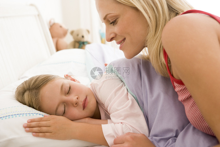在床上微笑着醒来的年轻女孩孩子们孩子时间妈妈睡衣家庭生活家长水平卧室女儿图片