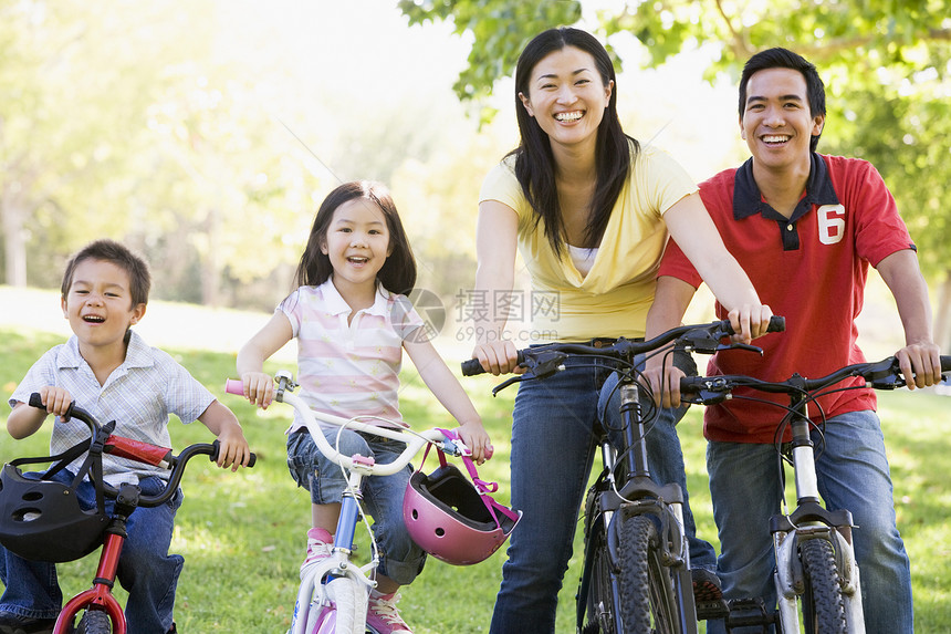 家庭在户外的自行车上微笑着公园男性父亲孩子们母亲女士骑术父母享受山地图片