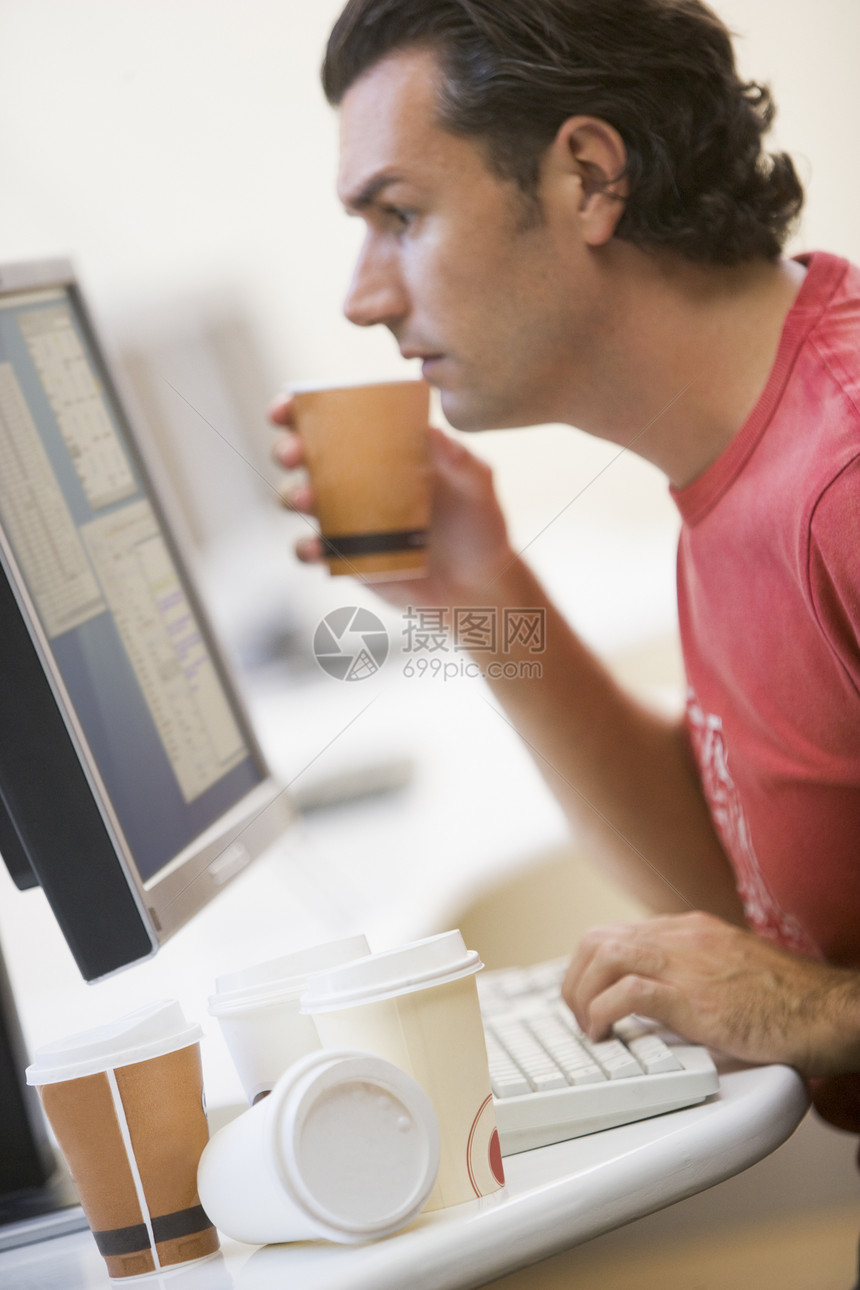 男人在电脑房里 有很多空咖啡杯图片