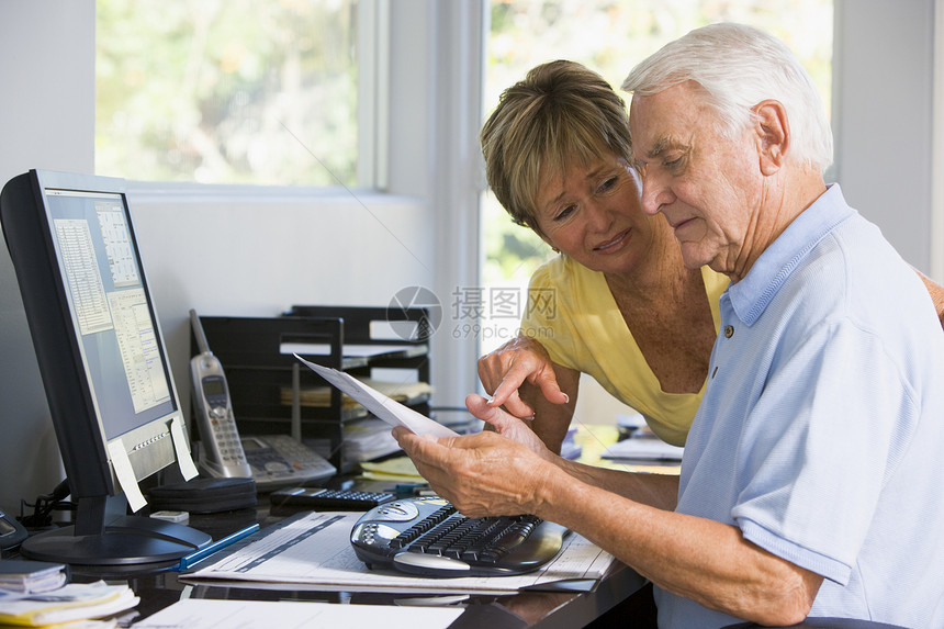 家庭办公室有计算机和文件的夫妇阅读债务电脑技术微笑工作站女士帐单两个人女性图片