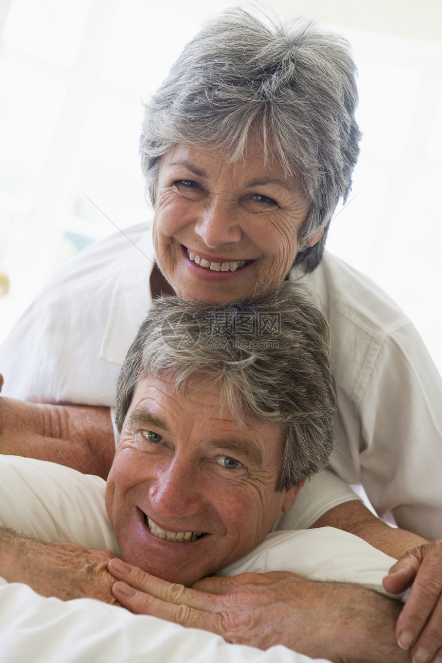 夫妻在卧室放松和微笑妻子丈夫男人女士男性苏醒两个人感情退休睡衣图片
