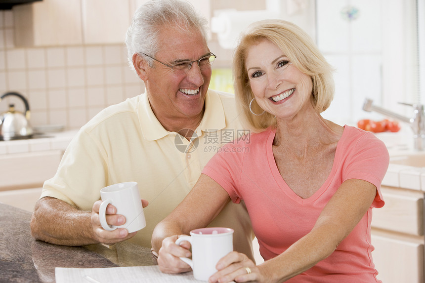 在厨房的一对夫妇 咖啡笑着丈夫女士微笑男性一杯茶男人长度水平妻子团结图片