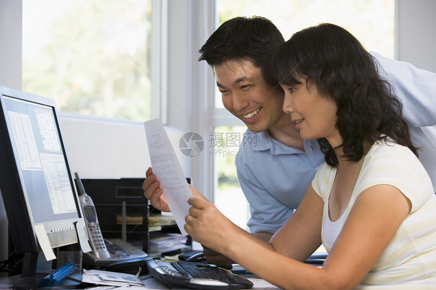 家庭办公室的情侣 带着电脑和文件微笑成人工作站文书夫妻妻子学习女士工作技术阅读图片