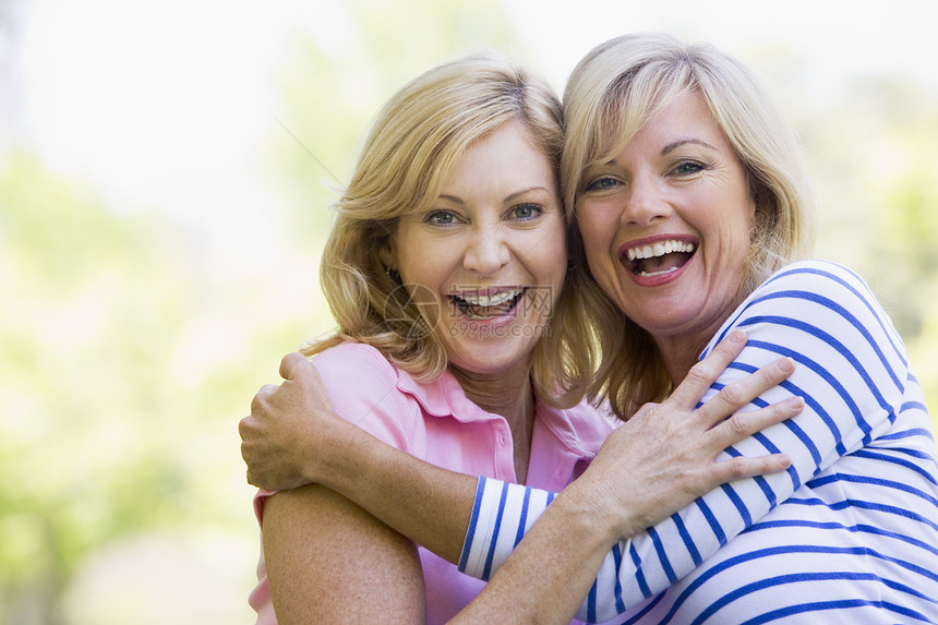 两个女性户外拥抱和微笑图片