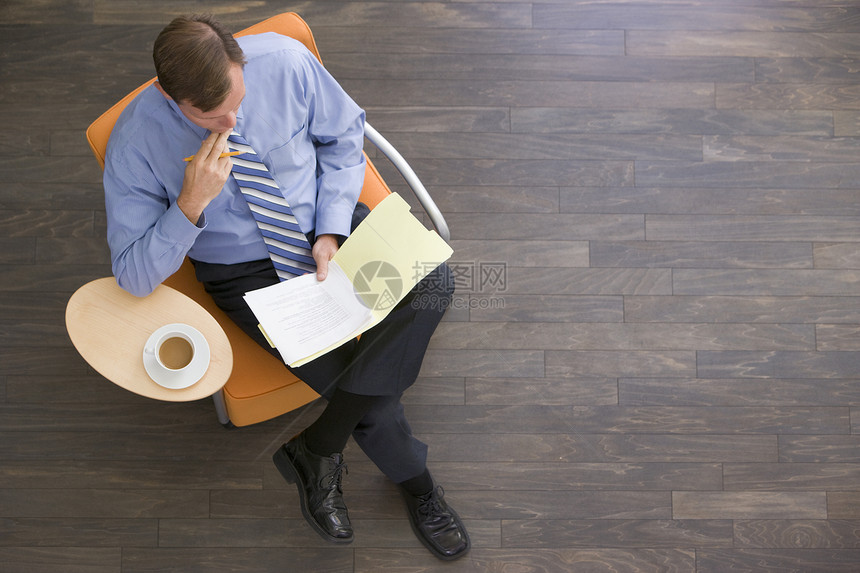坐在室内的商务人士与咖啡和文件夹坐在一起商业高架办公室一杯茶阅读座位学习椅子门厅文档图片