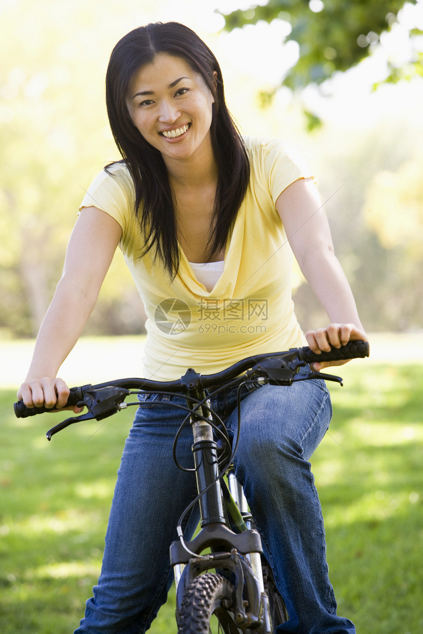 骑自行车微笑的妇女世代女性山地公园骑术踪迹享受农村相机图片
