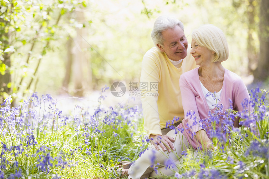 夫妻坐在户外 鲜花微笑男性两个人森林男人女性季节水平野花女士农村图片