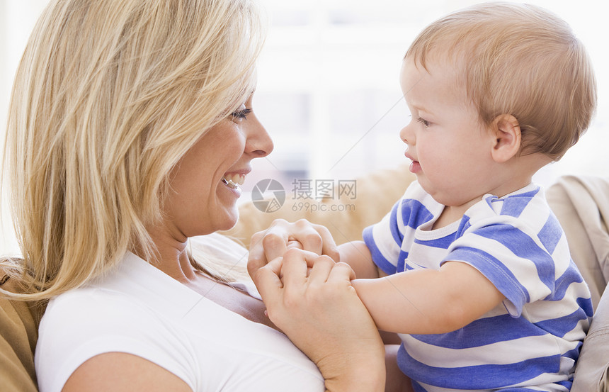 母亲在起居室抱着婴儿微笑玩具拥抱家庭女儿妈妈家长休息室笑声客厅女孩图片