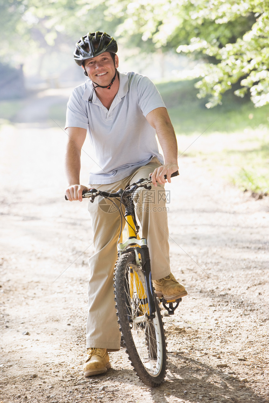 骑自行车的户外男人微笑着爱好农村骑术头盔男性山地安全帽活动相机享受图片