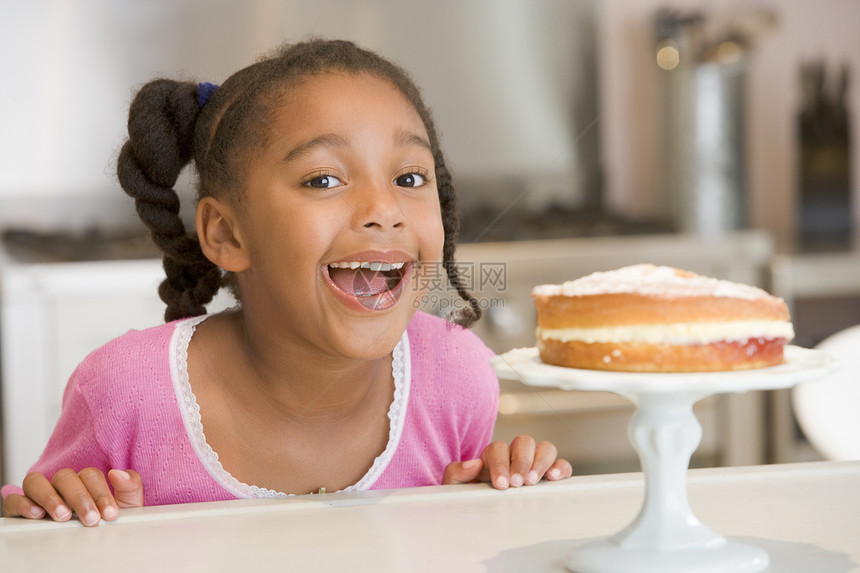 厨房里的年轻女孩 在柜台上笑着看蛋糕图片