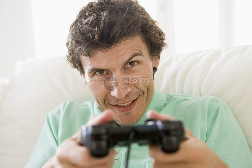 在客厅里玩游戏的人笑着俏皮娱乐成人乐趣控制器男性家庭游戏电脑游戏技术图片
