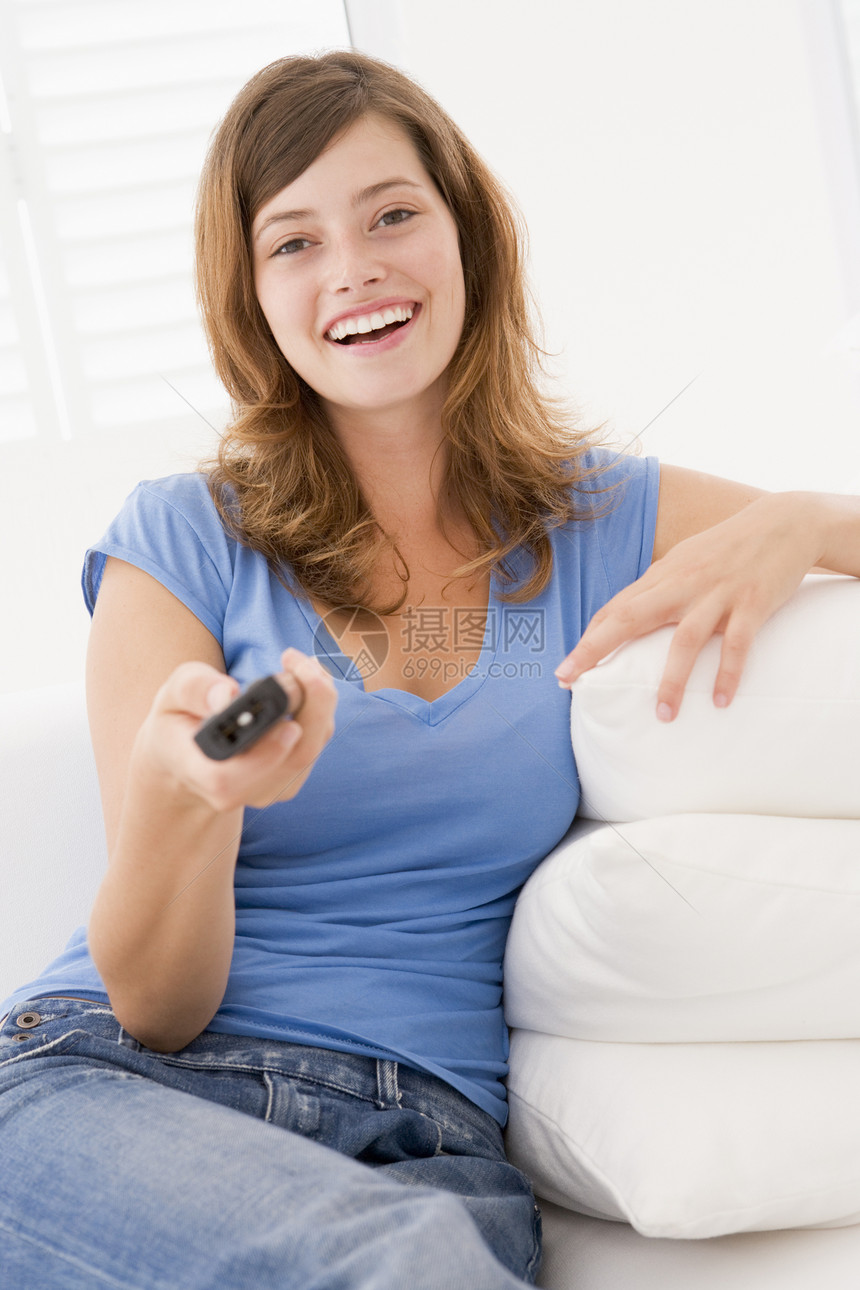 女用遥控器微笑着的客厅妇女频道家庭电视技术图片