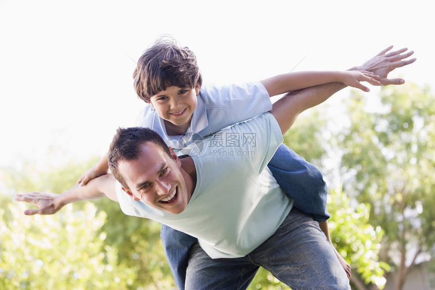 男人和小男孩在户外玩飞机 微笑着图片