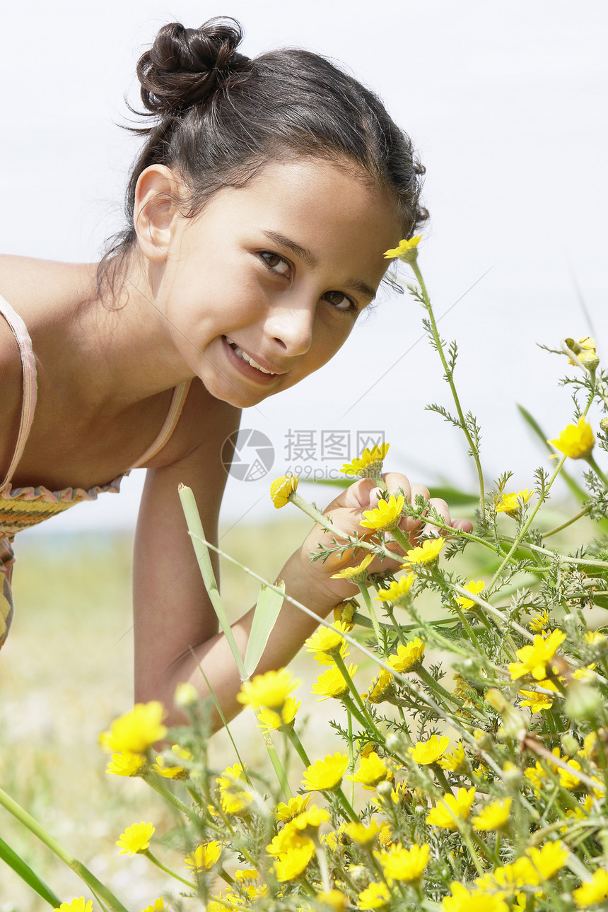 女孩闻闻鲜花植物植物群表情孩子们快乐生命童年自然世界青春期摄影图片