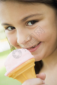 女孩户外吃冰淇淋和微笑的年轻女孩焦距零食情绪阶段情感糖果食物公园女性奶制品背景图片